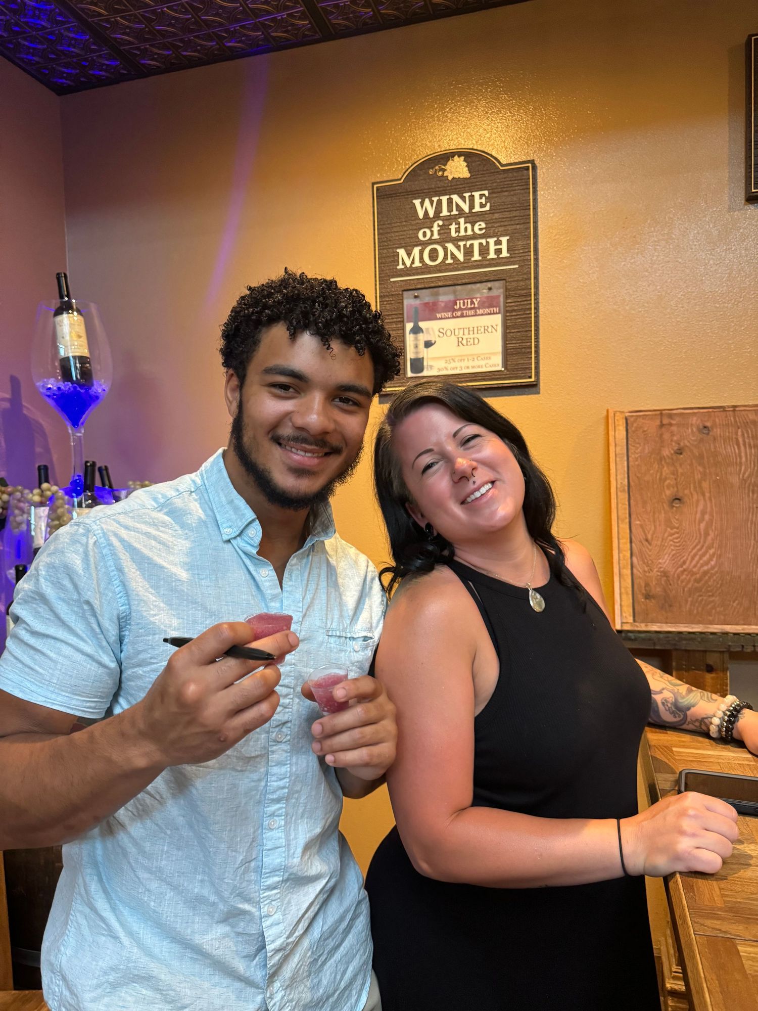 Friends posing together at a casual wine bar with wooden decor.