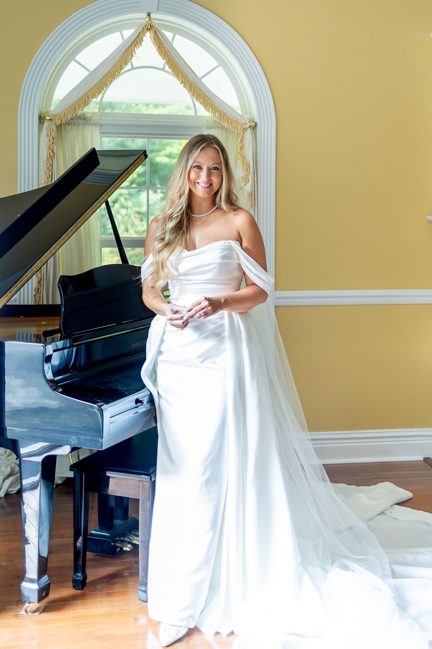 Elegant bridal portraits in a yellow room with a grand piano and arched window.