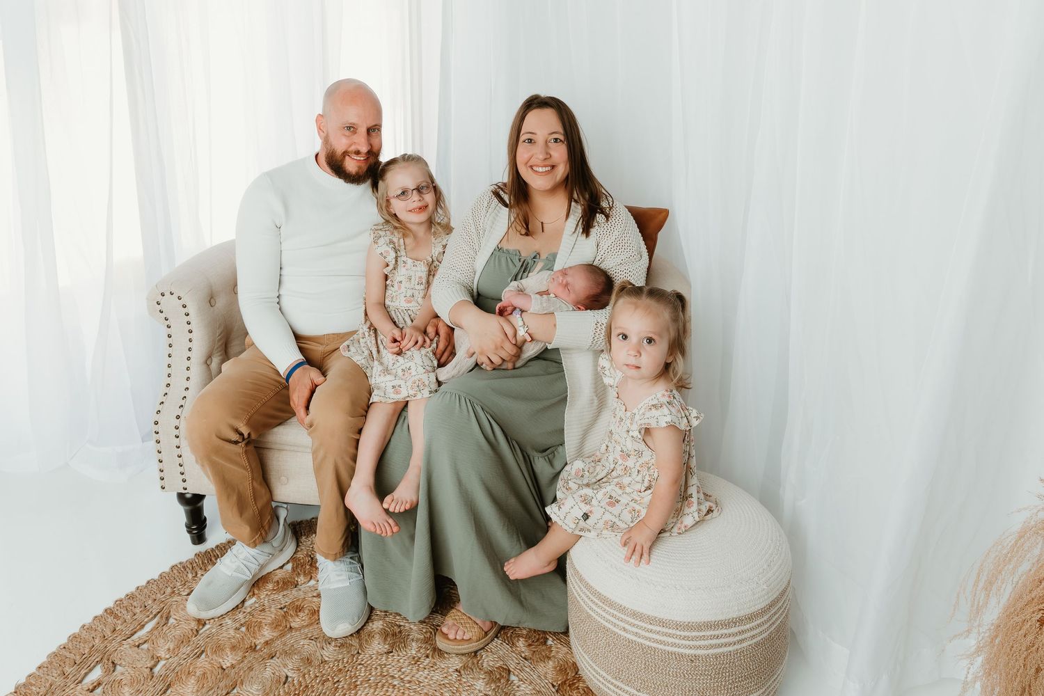 A cozy family moment on a white sofa with sunlight streaming through the window.