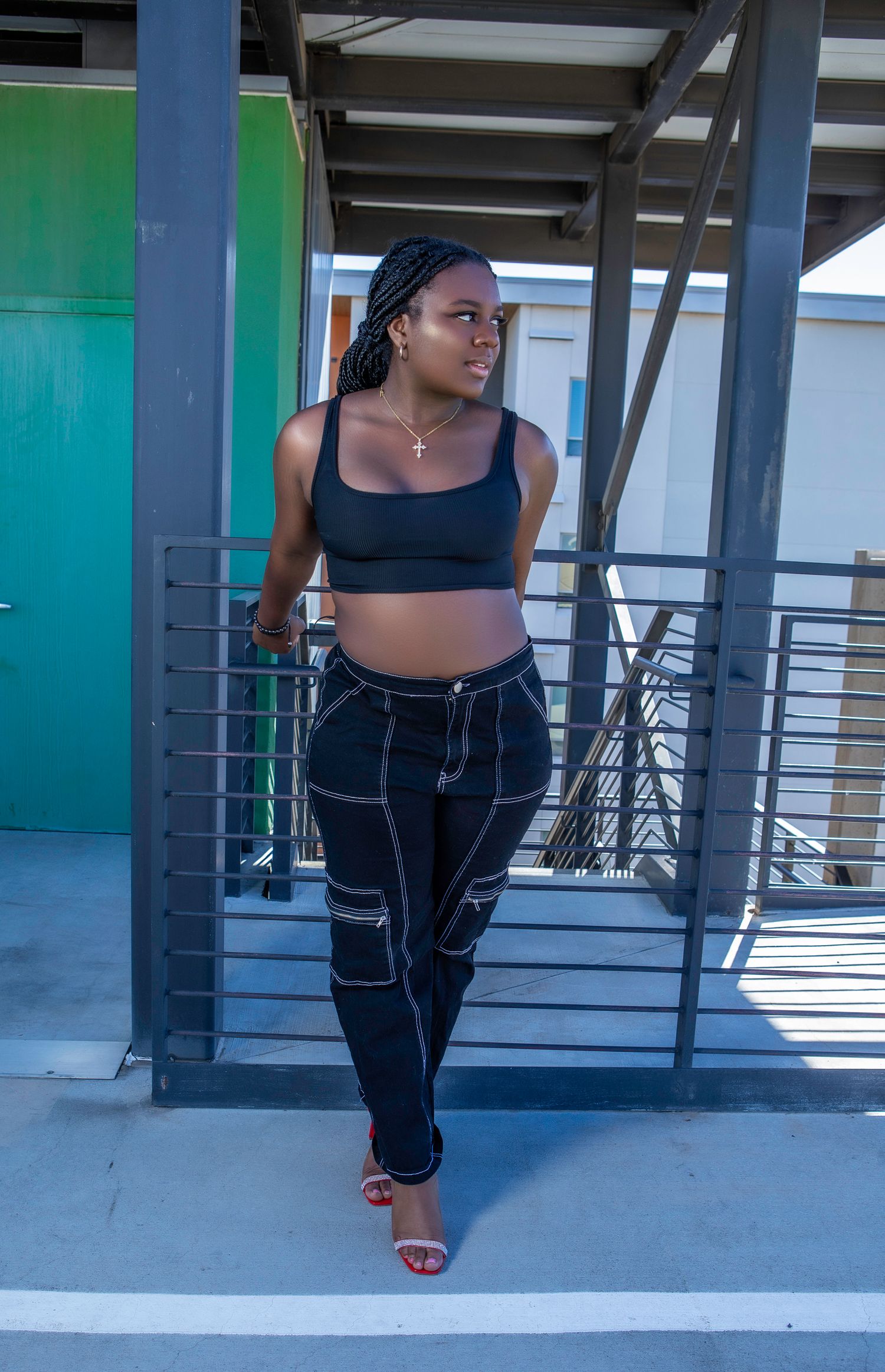 Person in athletic wear strikes dynamic poses against blue and green industrial backdrop.