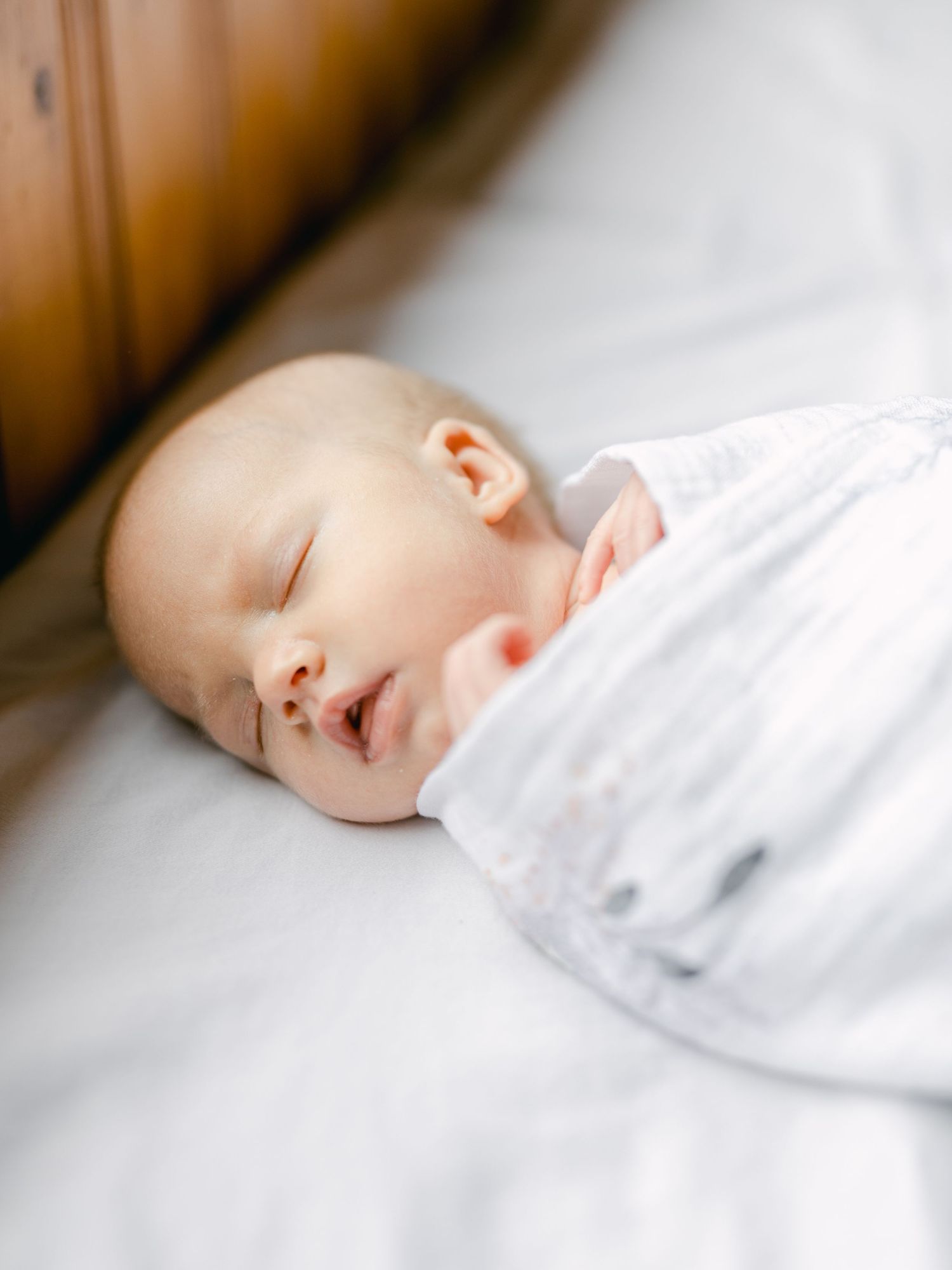 Peaceful sleeping baby in soft white bedding.