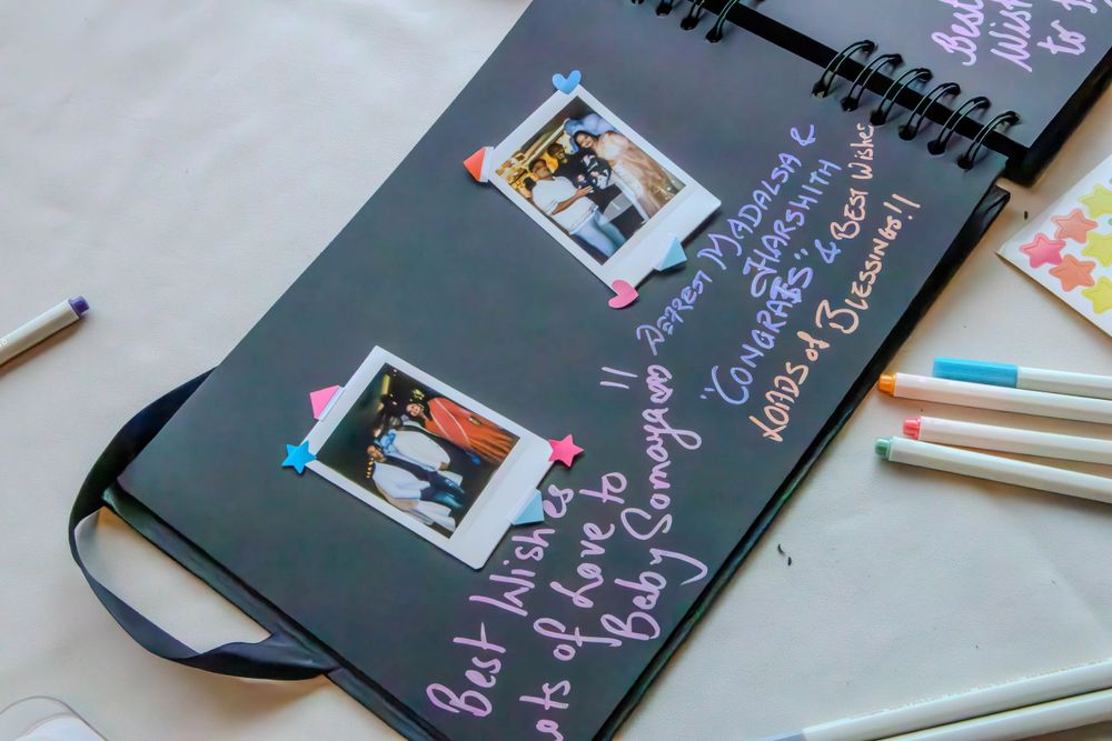 Guest book with polaroid photos and handwritten messages on dark background.