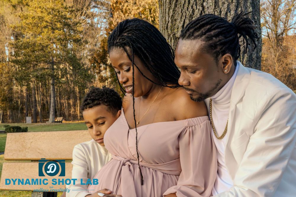 Family in coordinated outfits sharing an intimate moment on a park bench during autumn.