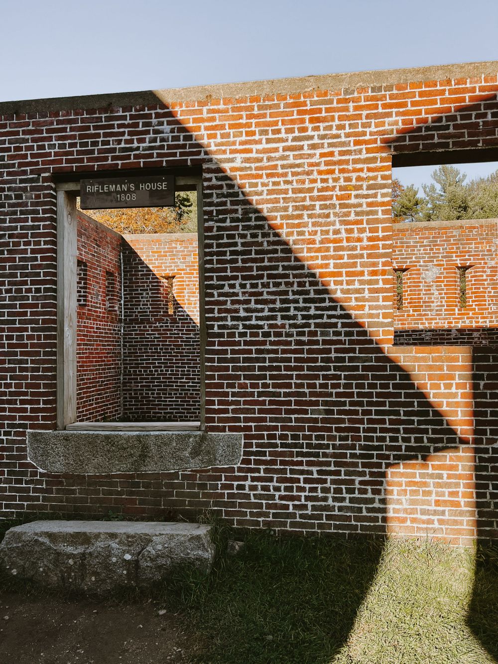 Historic red brick fortification walls create geometric shadows and arched passageways.