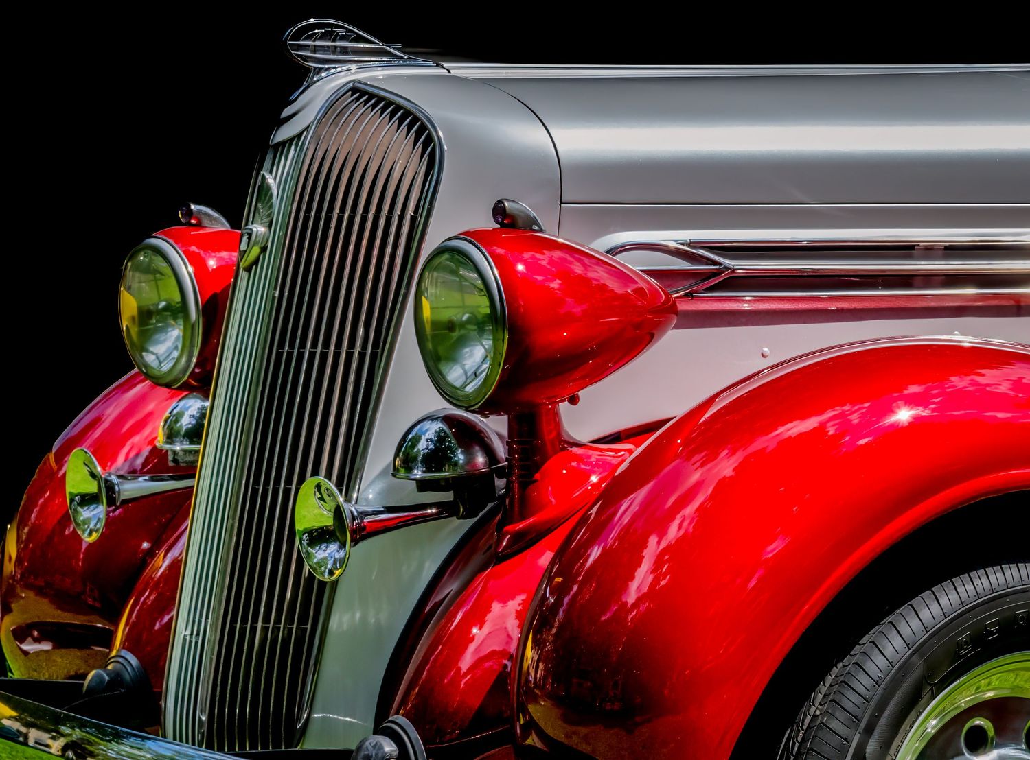 Detail shots of a restored vintage red automobile showing chrome trim and classic styling.