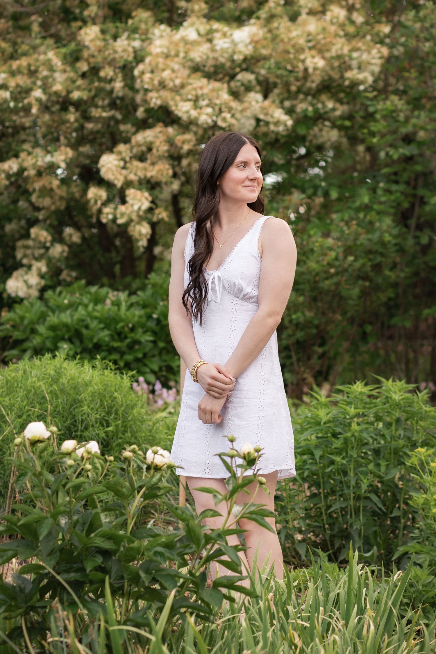 Mother and daughter share a joyful moment together in a lush garden wearing matching pink dresses.