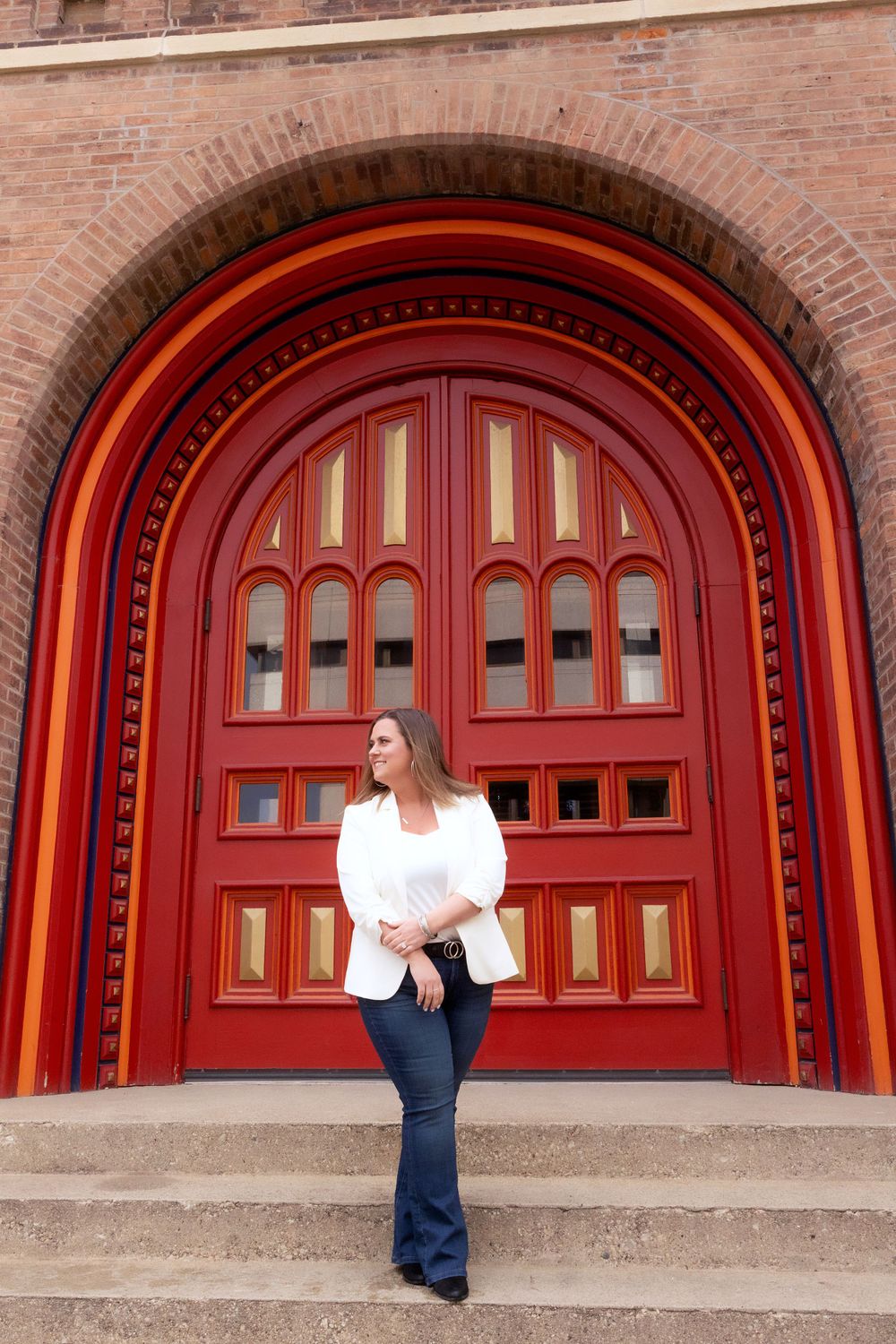 Classic white blazer ensemble photographed in front of ornate red architectural doorway.