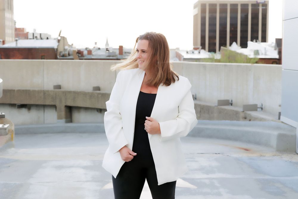 Stylish business attire on display against modern city rooftop setting with architectural elements.
