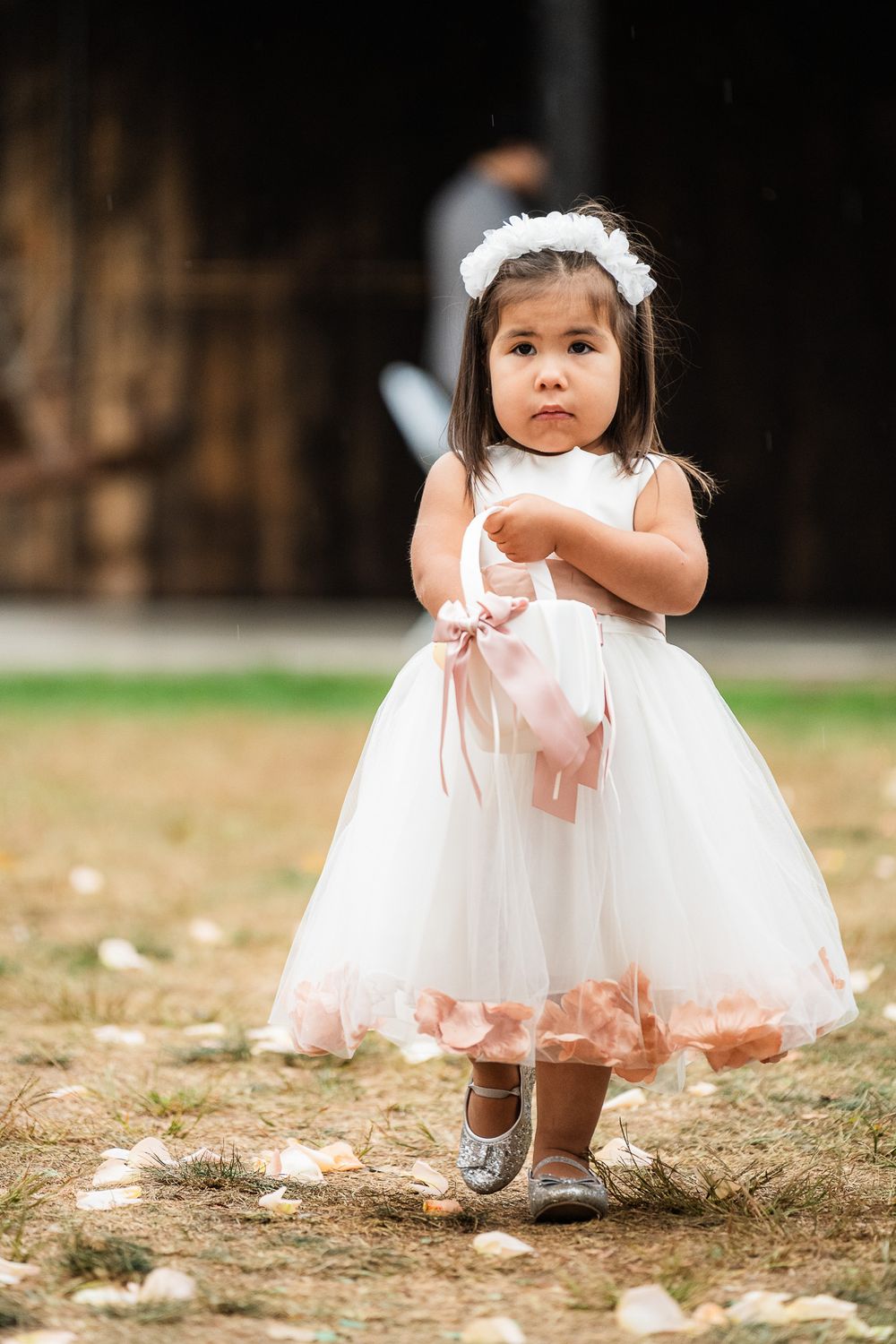 Small flower girl in white tulle dress with pink petals dances at outdoor event. Pittsburgh Wedding Photography, Videography