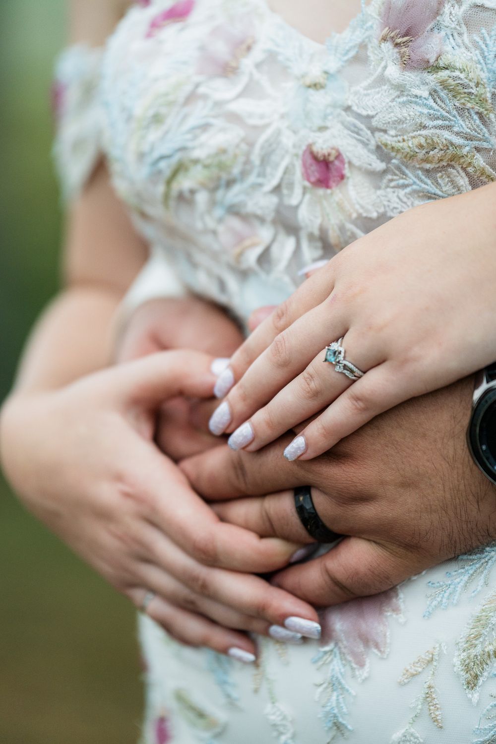 Close-up of hands showing an engagement ring against a floral embroidered dress. Pittsburgh Wedding Photography, Videography