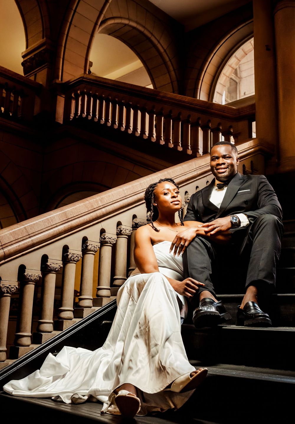 A couple pose elegantly on a grand marble staircase at Allegheny County Courthouse. Getting photography by EternalLensMedia.com