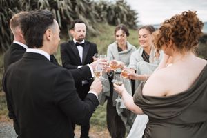 Wedding party celebrating outdoors with champagne toasts and laughter.