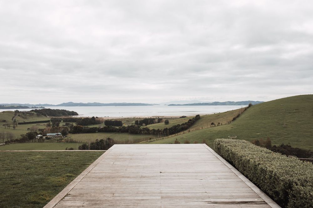 Coastal wedding venue deck overlooks dramatic ocean and rolling hillside views.