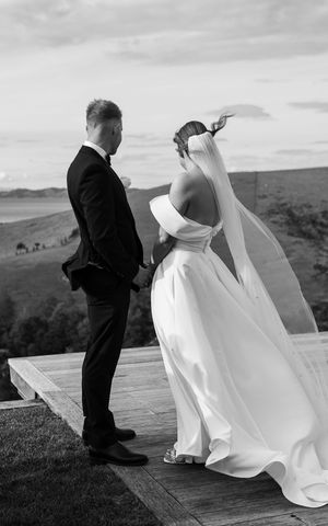 Black and white photos of couple sharing intimate moments on hilltop during wedding ceremony.