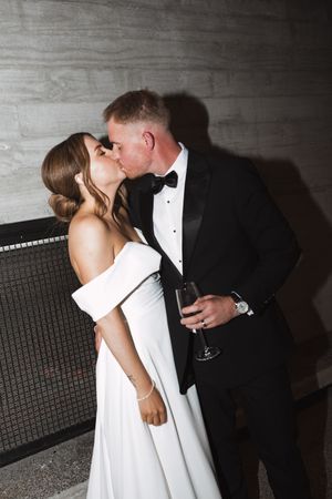 Romantic couple in formal attire sharing an intimate moment at an elegant event.