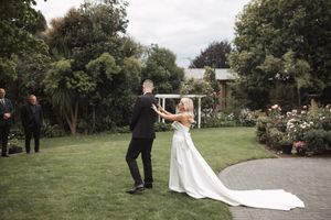 Wedding ceremony taking place in lush garden setting with natural greenery.