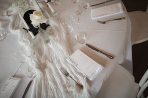 Wedding detail shots of white fabric and paper elements on light background.