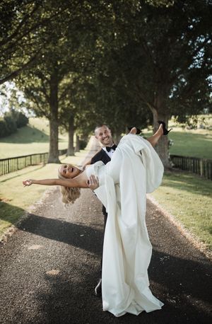 Artistic sequence of bride in flowing white dress twirling on outdoor path.