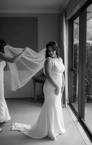 Bride twirls in flowing white dress creating movement in black and white indoor portraits.
