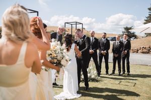 Wedding celebration with guests cheering during outdoor ceremony.