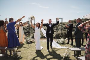 Wedding party toasting and celebrating indoors in formal attire.
