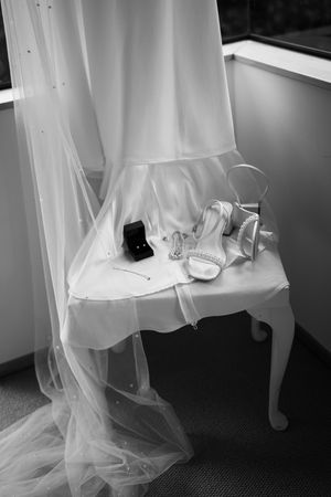 Black and white detail shots of wedding dress and veil flowing against dark background.