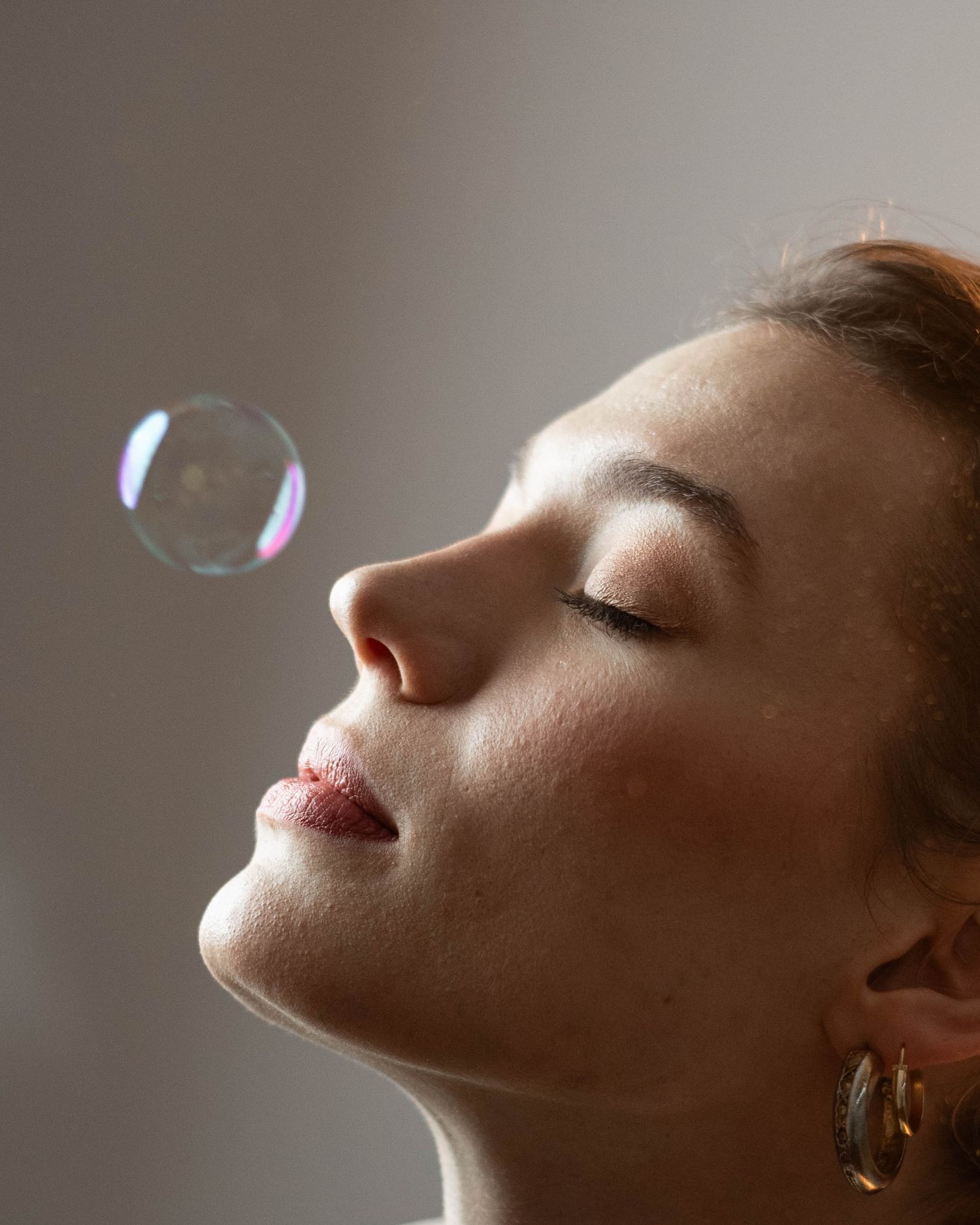Close-up sequence showing soap bubbles floating against a neutral background.