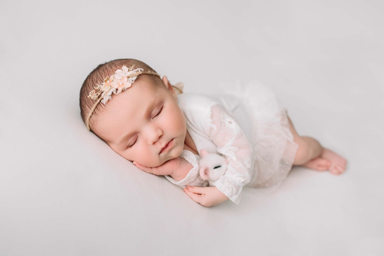 Sleeping newborn surrounded by boutique props in cozy photography studio near the Twin Cities