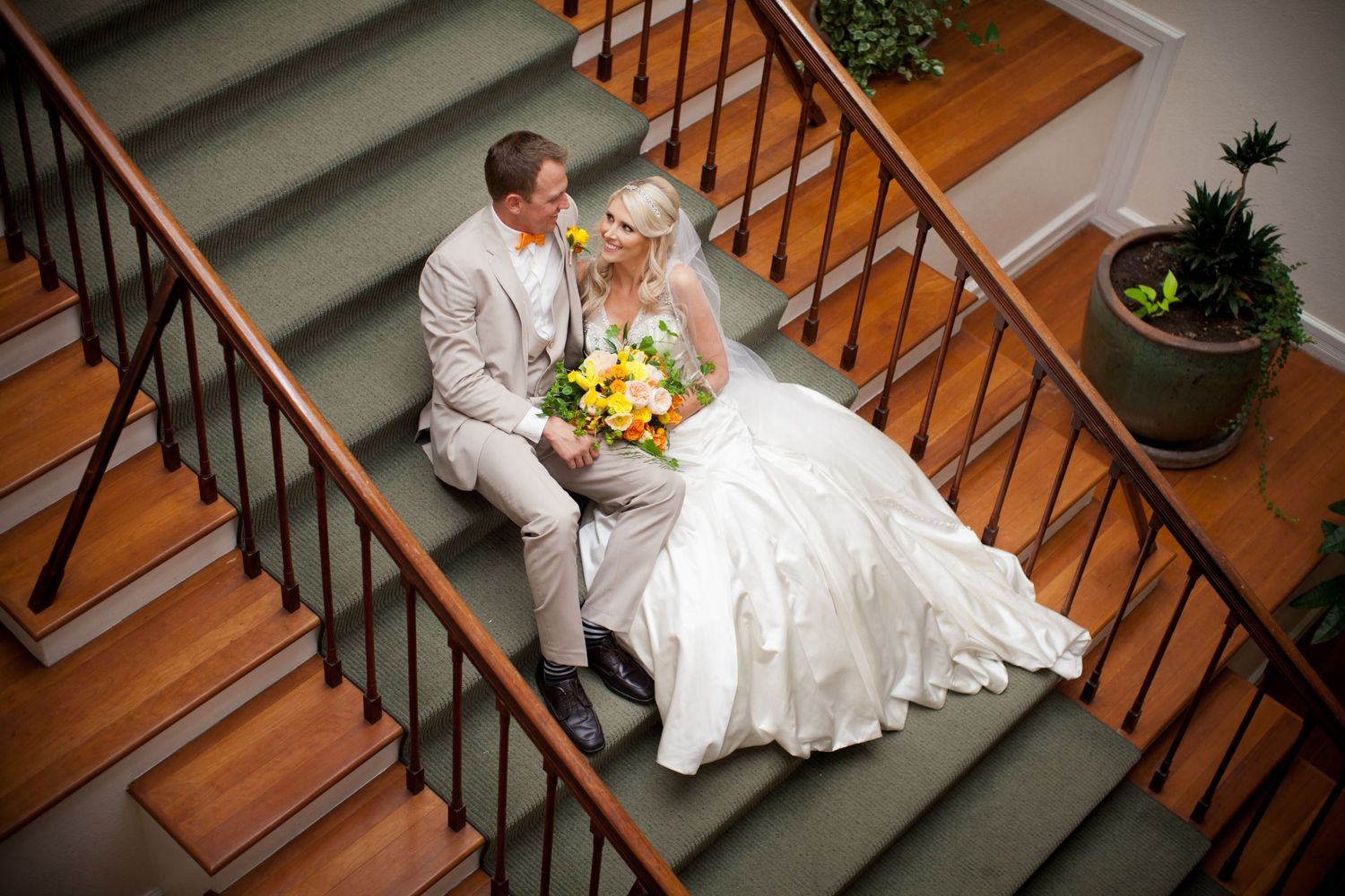 bride and groom sitting on steps looking at each other