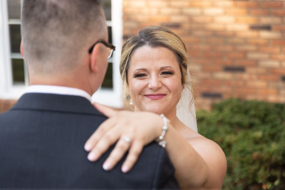 A joyful outdoor wedding portrait featuring a veil and classic formal attire.
