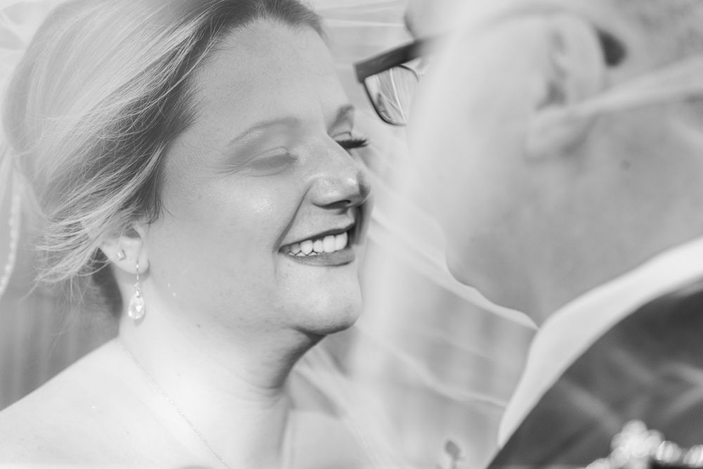 A black and white close-up of a joyful wedding moment captured in an intimate portrait.