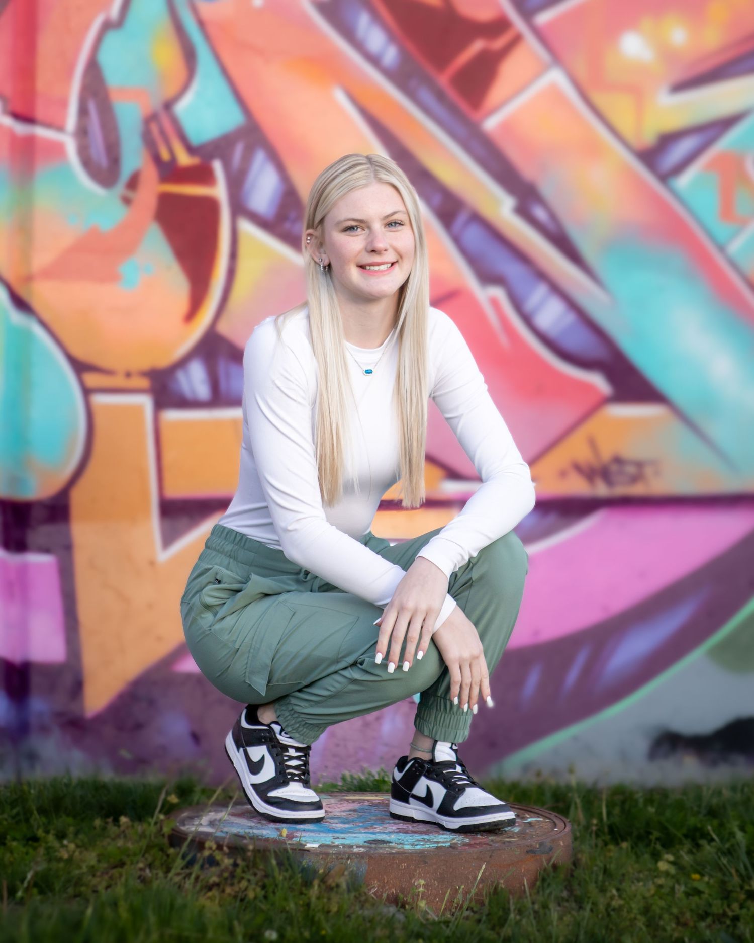 Urban style portraits against colorful graffiti wall wearing casual streetwear.
