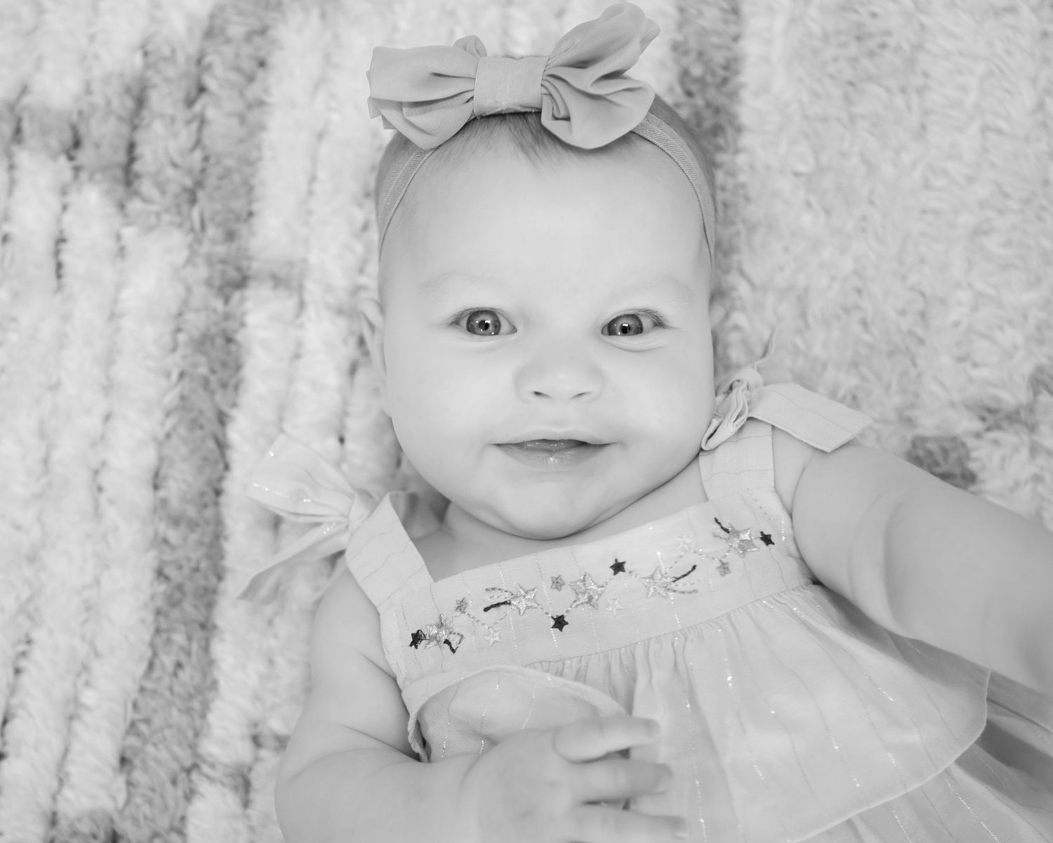 Black and white close-up portraits of baby with bow accessory.