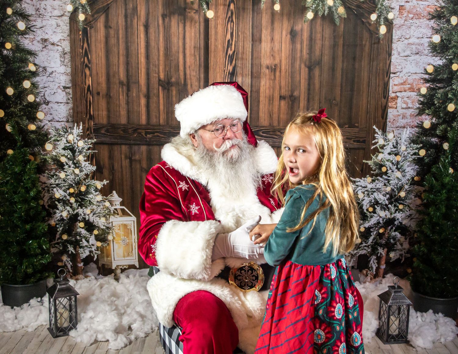 Holiday photo session setup with snowy winter decorations and rustic wooden backdrop.