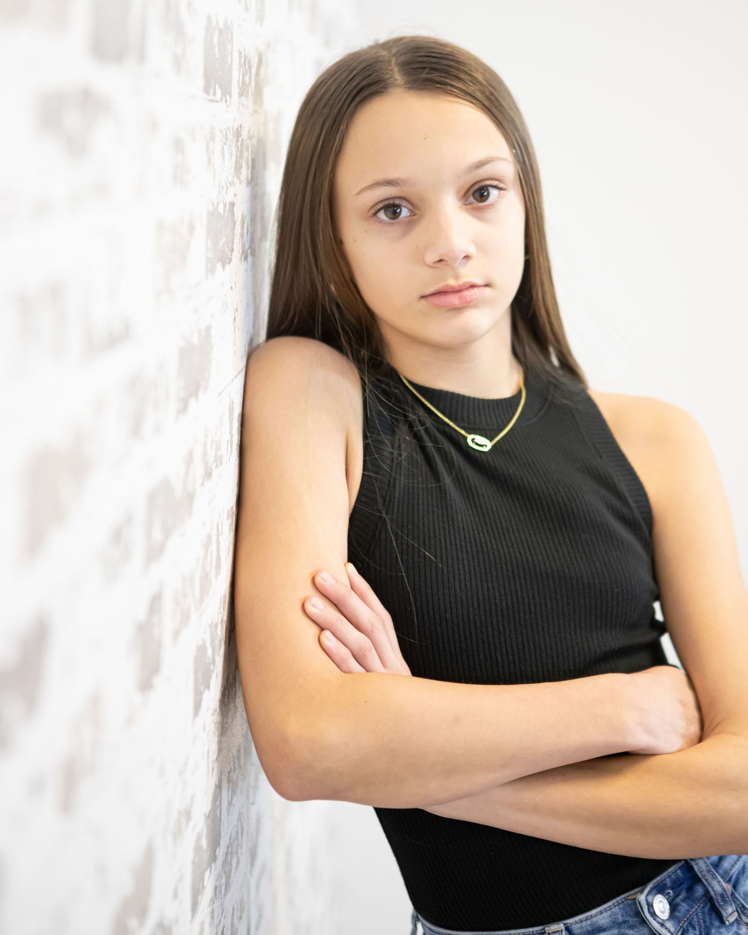 Studio portrait of someone in a black sleeveless top against a white background.