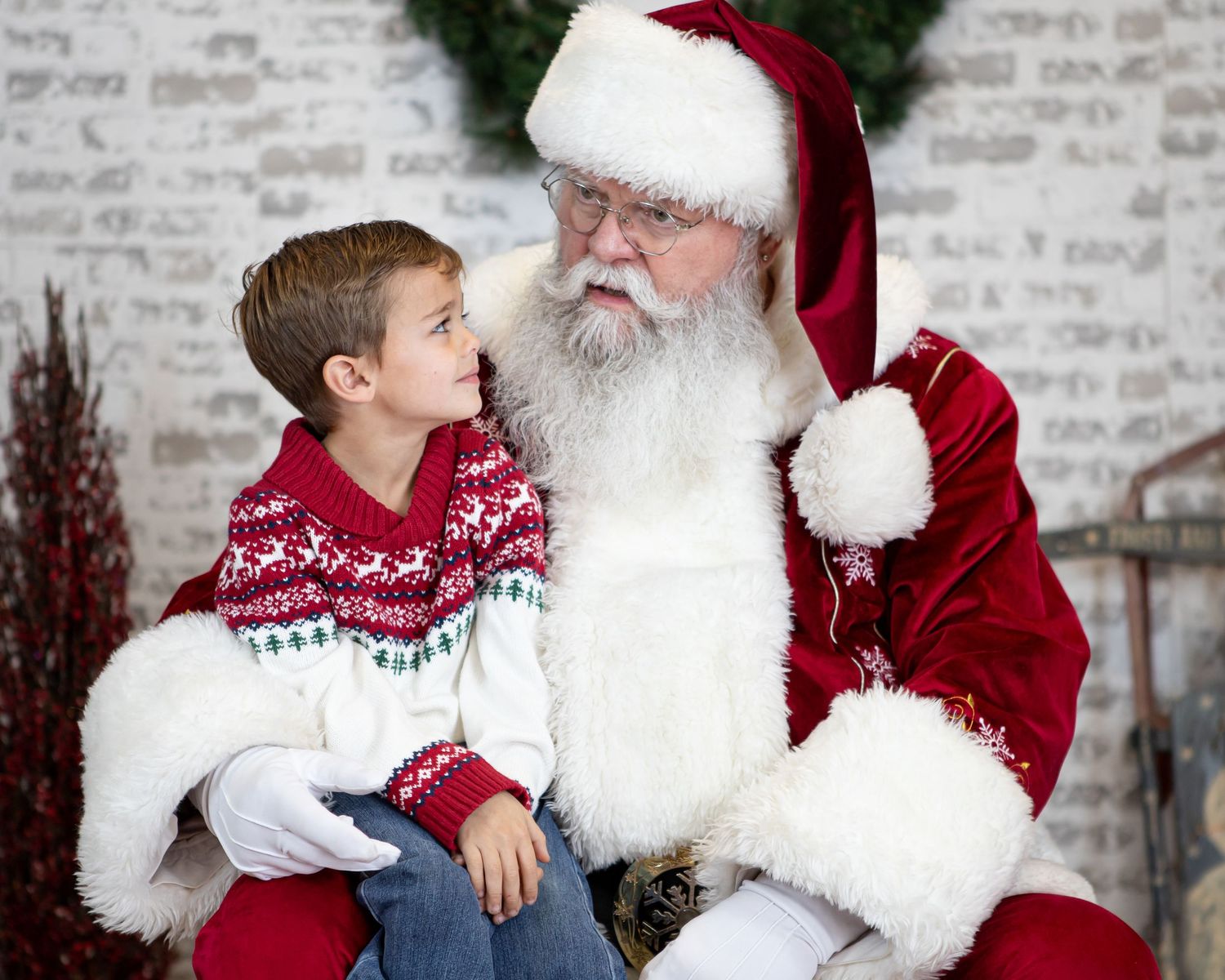 Holiday portrait session with traditional Christmas figure and child.