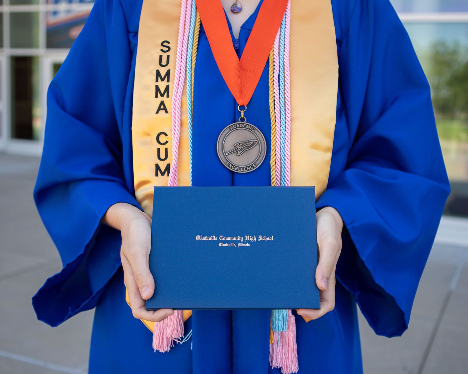 Close-up shots of academic regalia and graduation honors cords with diploma.