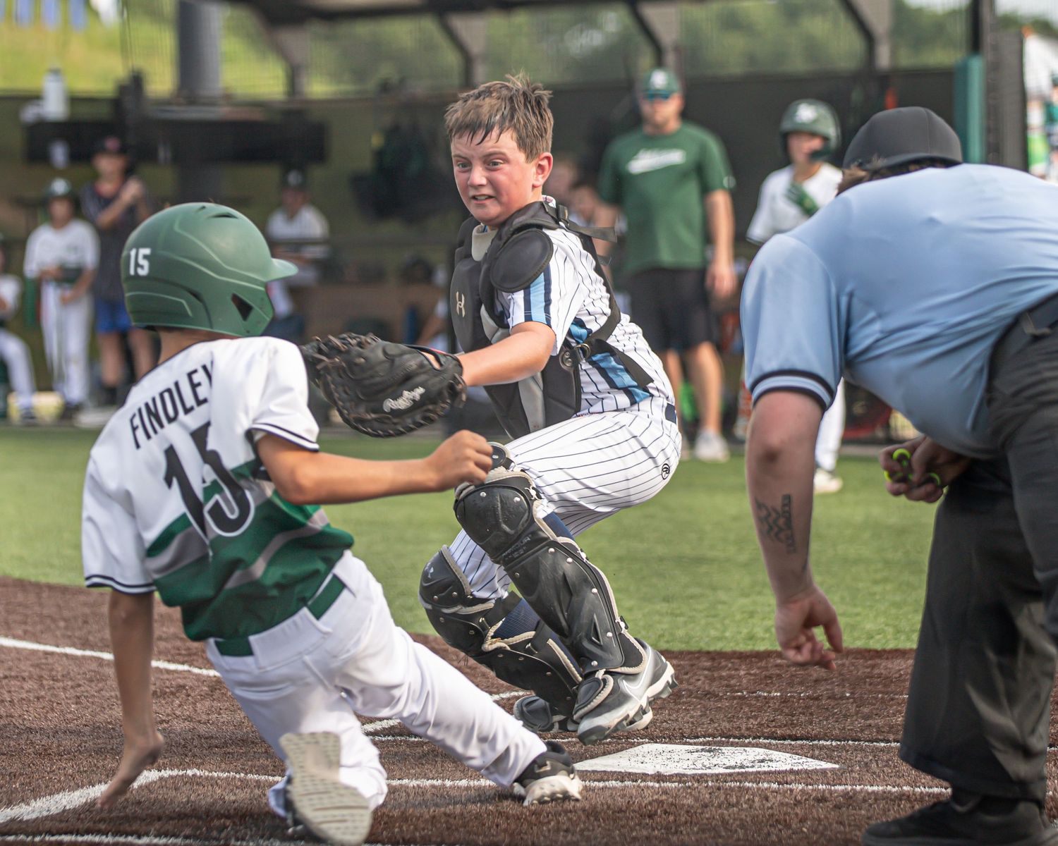 Baseball action sequence showing player sliding into base during game.