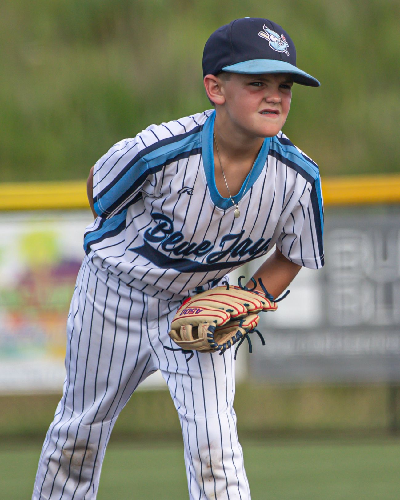 Baseball player in pinstriped uniform practicing fielding stance sequence.