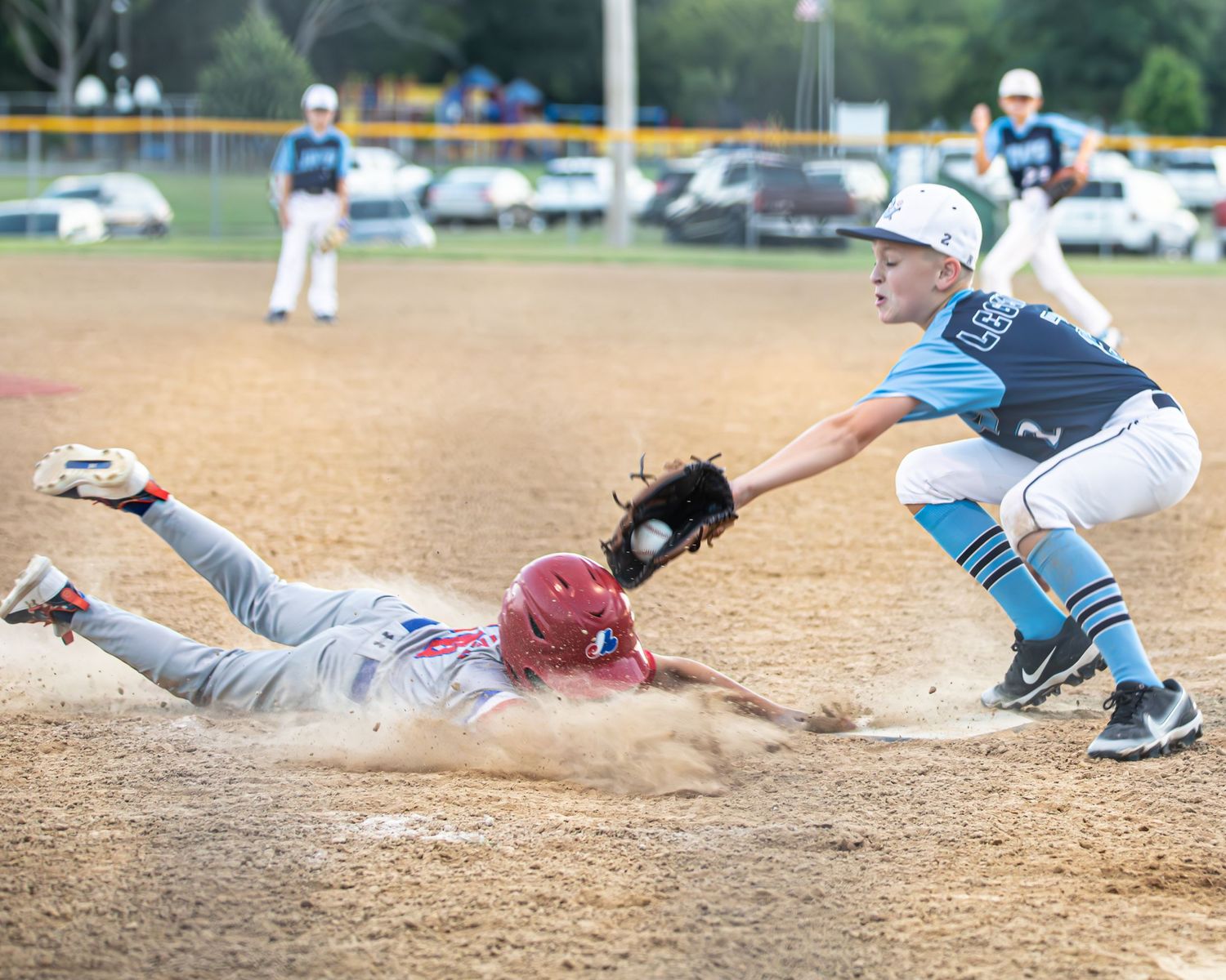 Dynamic baseball sliding sequence showing player diving into base with dust flying.
