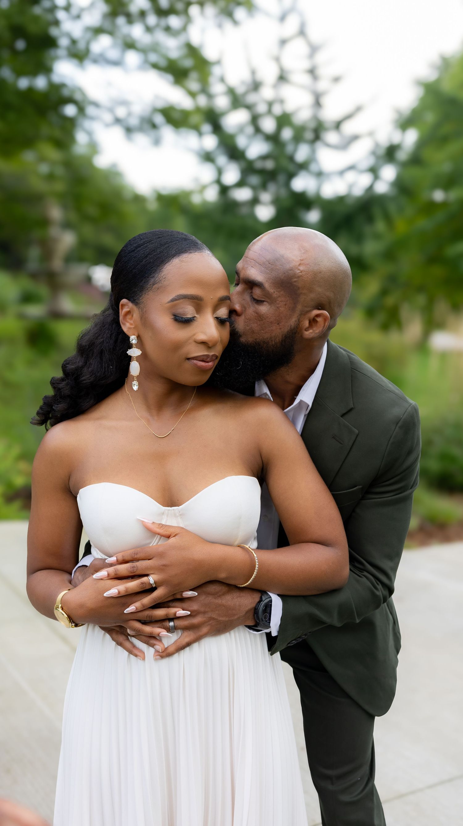 Romantic wedding portrait of a couple embracing in a garden setting.