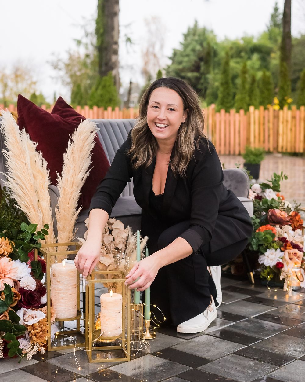 An event planner styles some pampas grass and smiles at the camera.