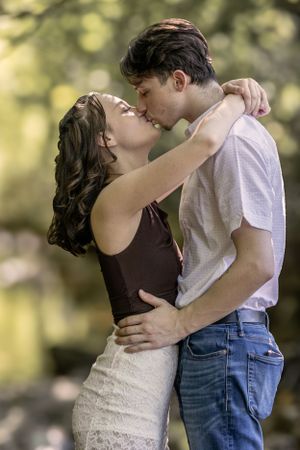 A romantic outdoor portrait of a couple sharing an intimate embrace in soft natural lighting.