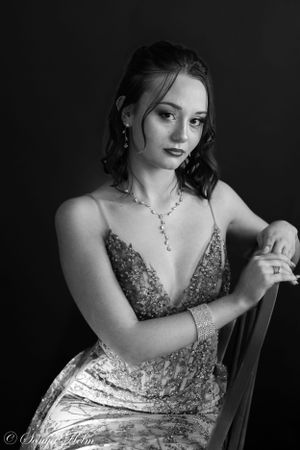 Black and white portrait showing elegant formal wear and classic studio pose.