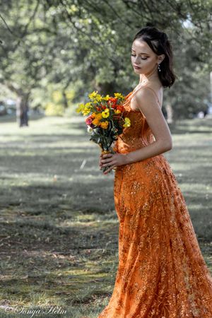 Dreamy autumn fashion photo featuring orange sequin dress and seasonal flowers.