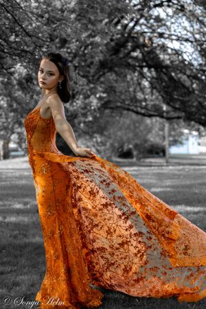An orange flowing gown creates dramatic contrast in a black and white landscape photo.