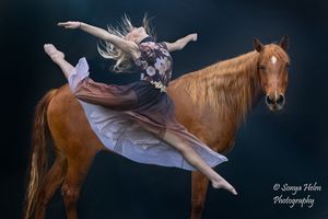 A dance photographer captures multiple exposure shots of a ballet dancer performing with a chestnut horse in dramatic lighting.