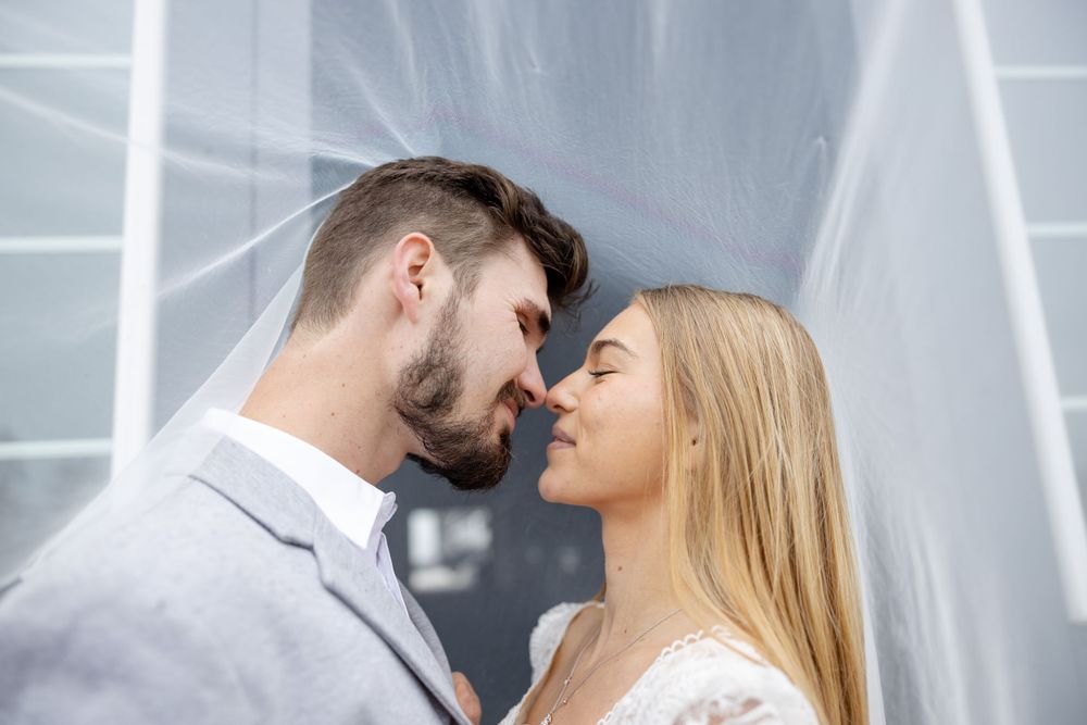 A romantic couple sharing an intimate embrace against a blurred background.