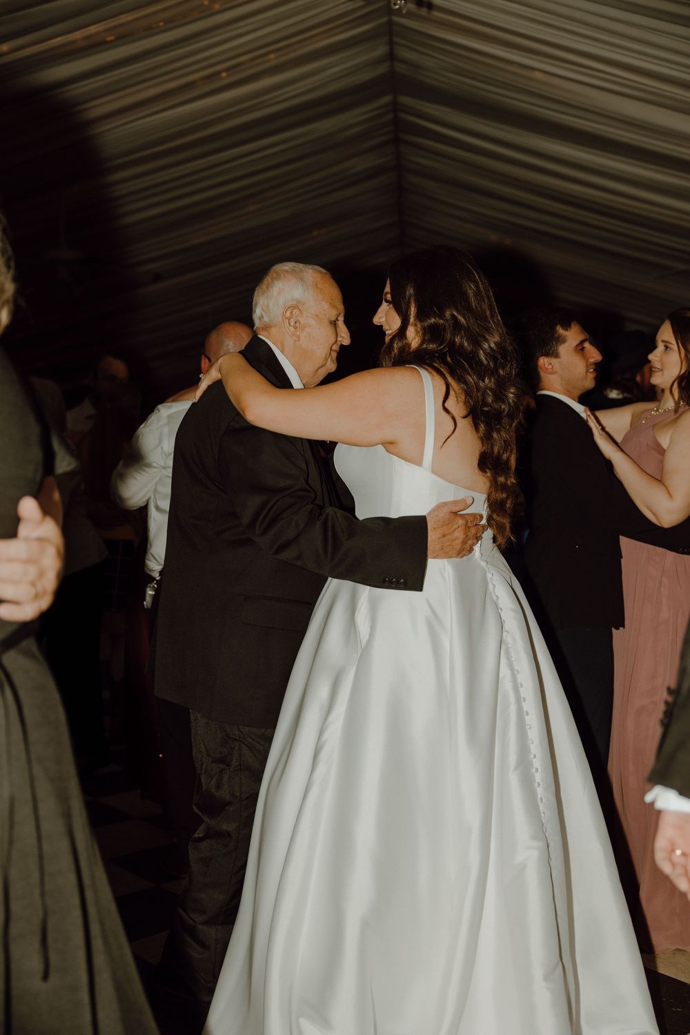 An intimate dance moment captured during a wedding reception in dim lighting.