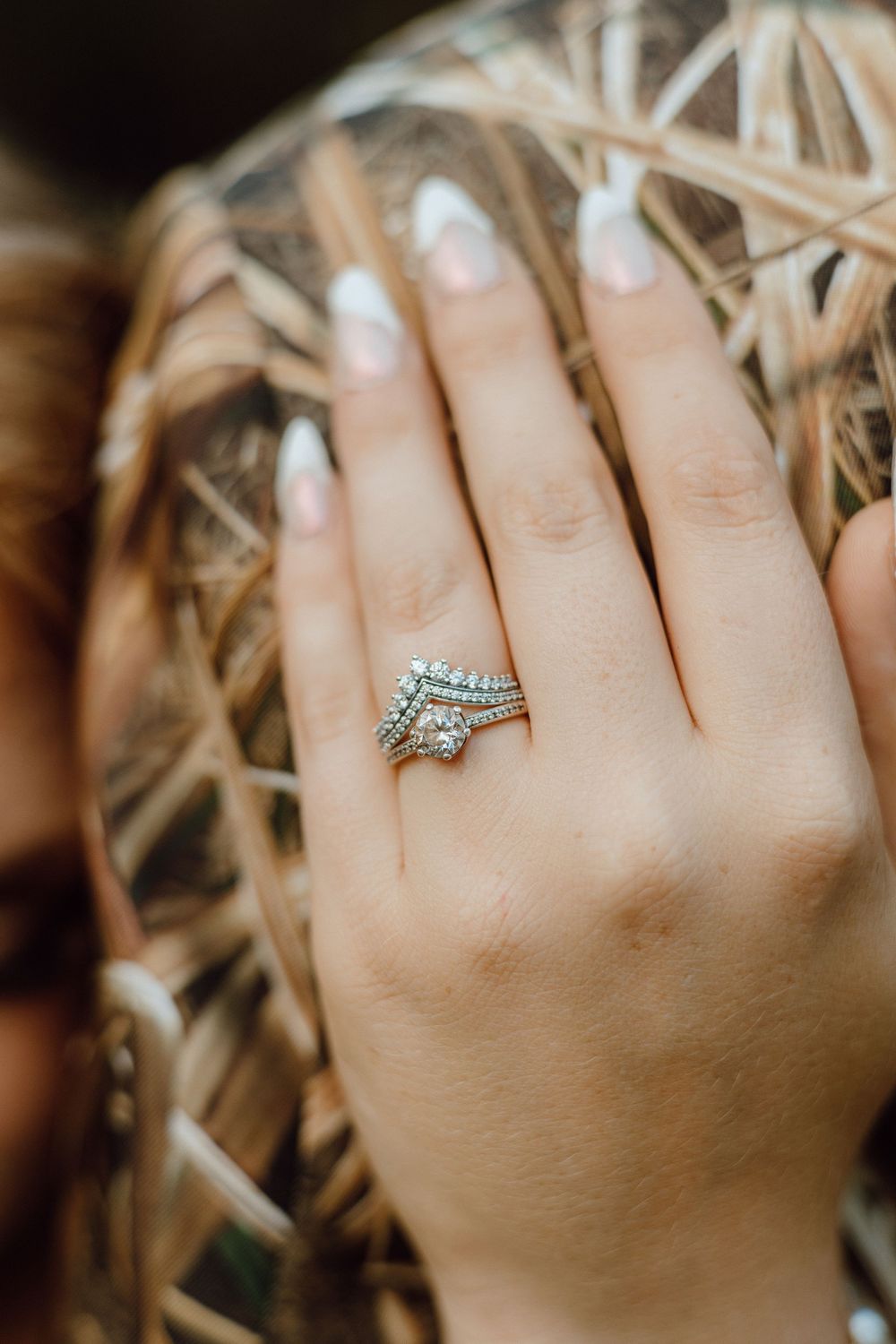 Close-up shots of a sparkling engagement ring with multiple bands on a hand.